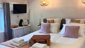 A hotel room with a bed, bedside table, TV, and a large window.