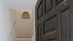 A staircase leading to a dark wooden door with a circular handle. - La Maison de Vaison (Vaison-la-Romaine)