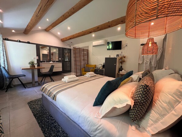 Une chambre moderne avec un grand lit, des tables de chevet, un bureau et un téléviseur.