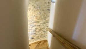 Un escalier en bois avec un mur de pierre en bas.