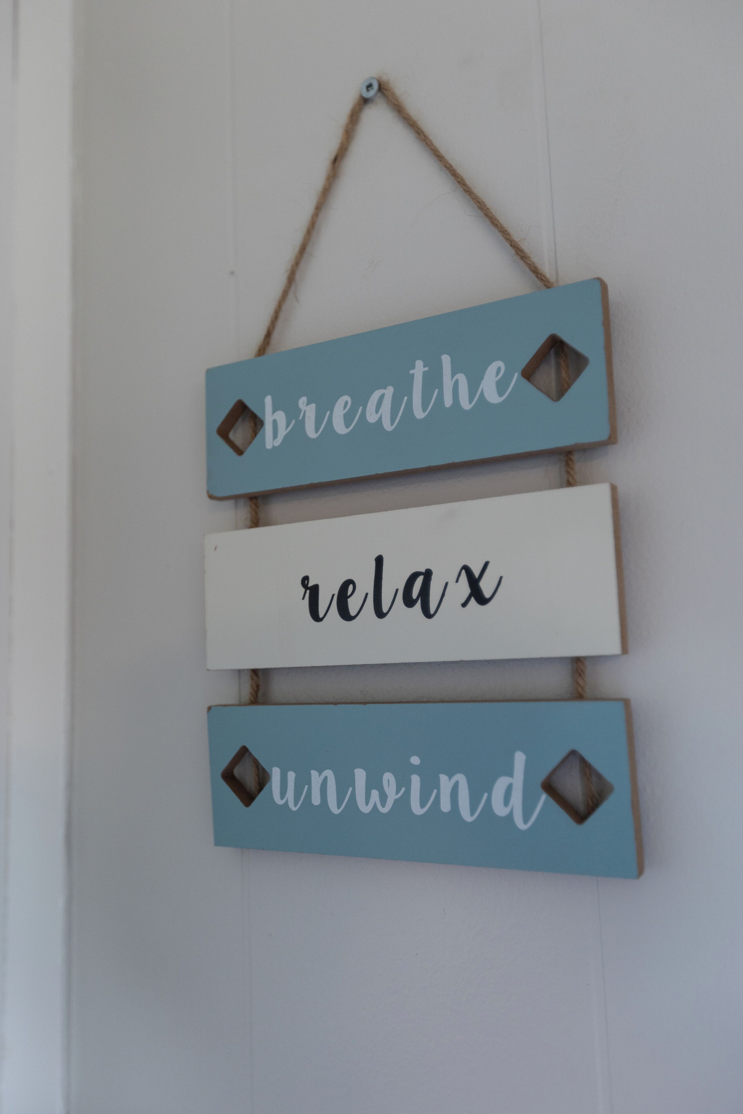 Un letrero en la pared con las palabras 'breathe', 'relax' y 'unwind' dispuestas verticalmente.