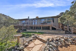 A modern two-story house with a balcony, stone pathway, and a bird feeder. - Dog-Friendly Retreat Near Thumb Butte (Prescott)