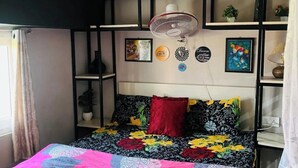Ein Schlafzimmer mit einem Bett, einem Deckenventilator und Wanddekorationen.