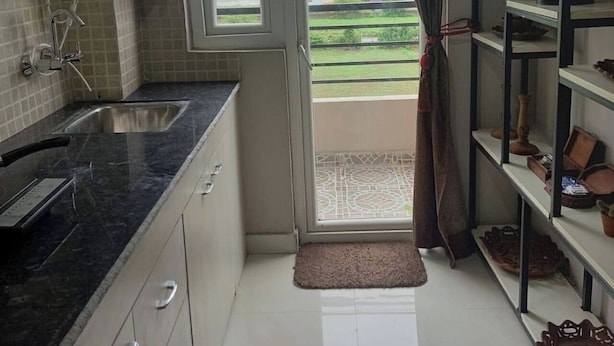 Eine Küche mit Spüle, Wasserspender und einem Fenster mit Blick auf Grünfläche.