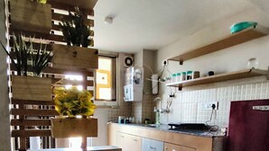 Eine kleine Küche mit Holzausziehtisch, integriertem Spülbecken und Kühlschrank.