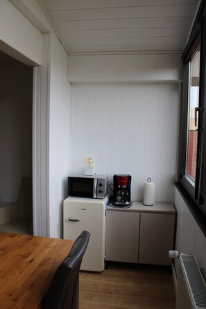 A compact kitchenette with a microwave, coffee maker, and refrigerator. - Modern apartment F423 up to 4 persons (Schönberg OT Holm)