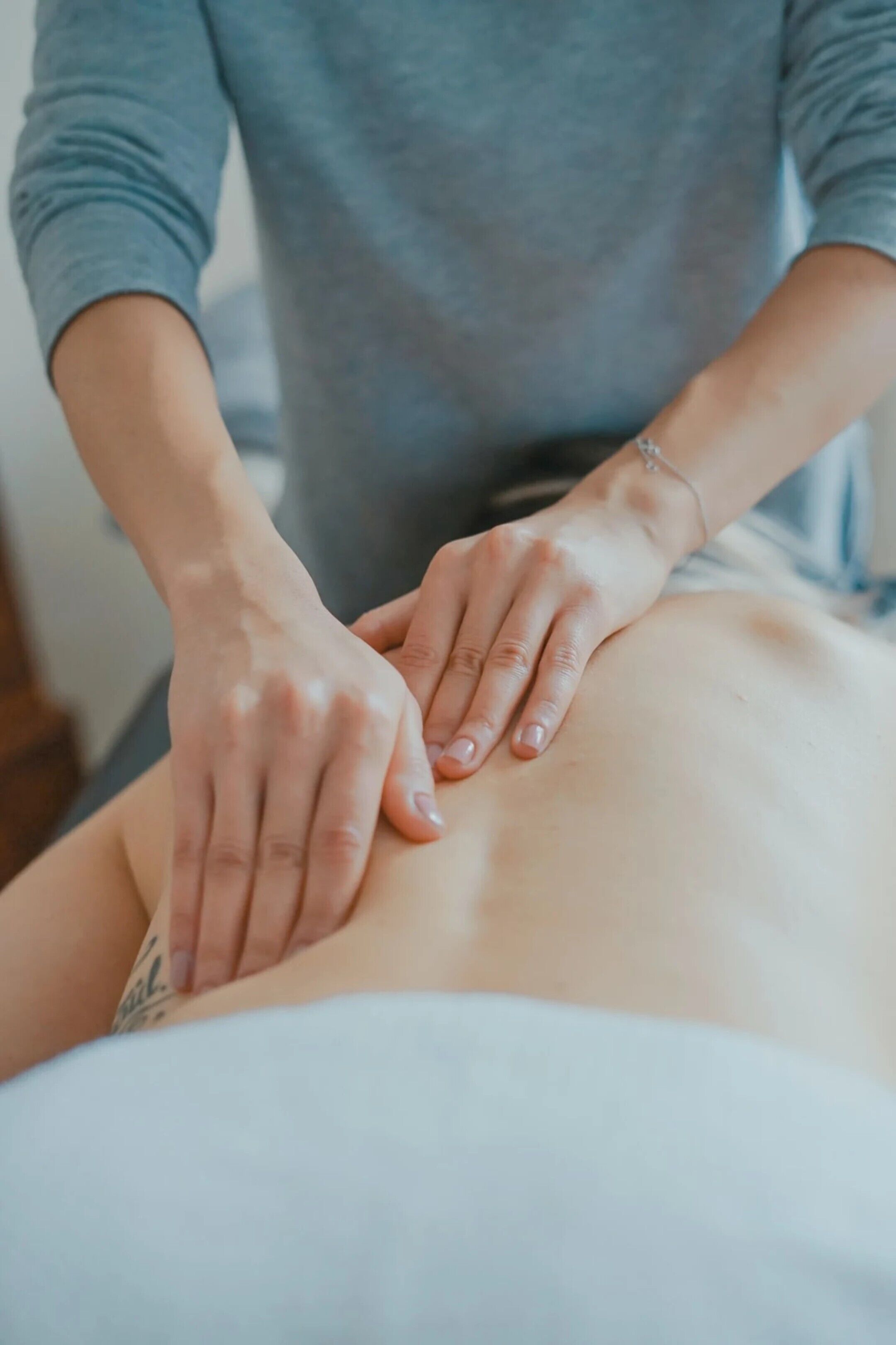 A person receiving a massage on a massage table.
