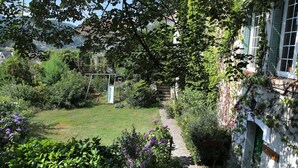 A garden with a basketball hoop, a swing set, and a path leading to a house with a sign reading 'HOPKINS'.