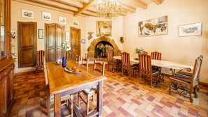 A dining area with wooden furniture, a fireplace, and artwork on the walls.