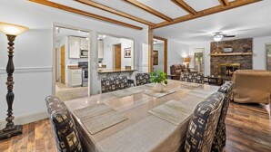 Un espace repas comprenant une grande table, des chaises et une lampe.