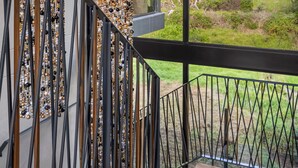 A modern staircase with a view of a natural landscape through large windows. - Tarentaal Kloof Villa in Higgovale. (Cape Town)