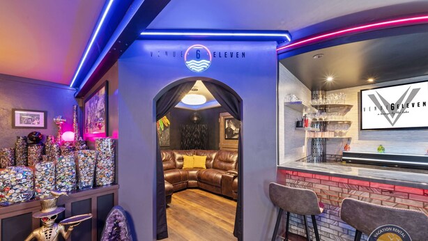 En bardisk med en bardisk, barstolar och en skylt med texten ”VENUE 6 ELEVEN”.