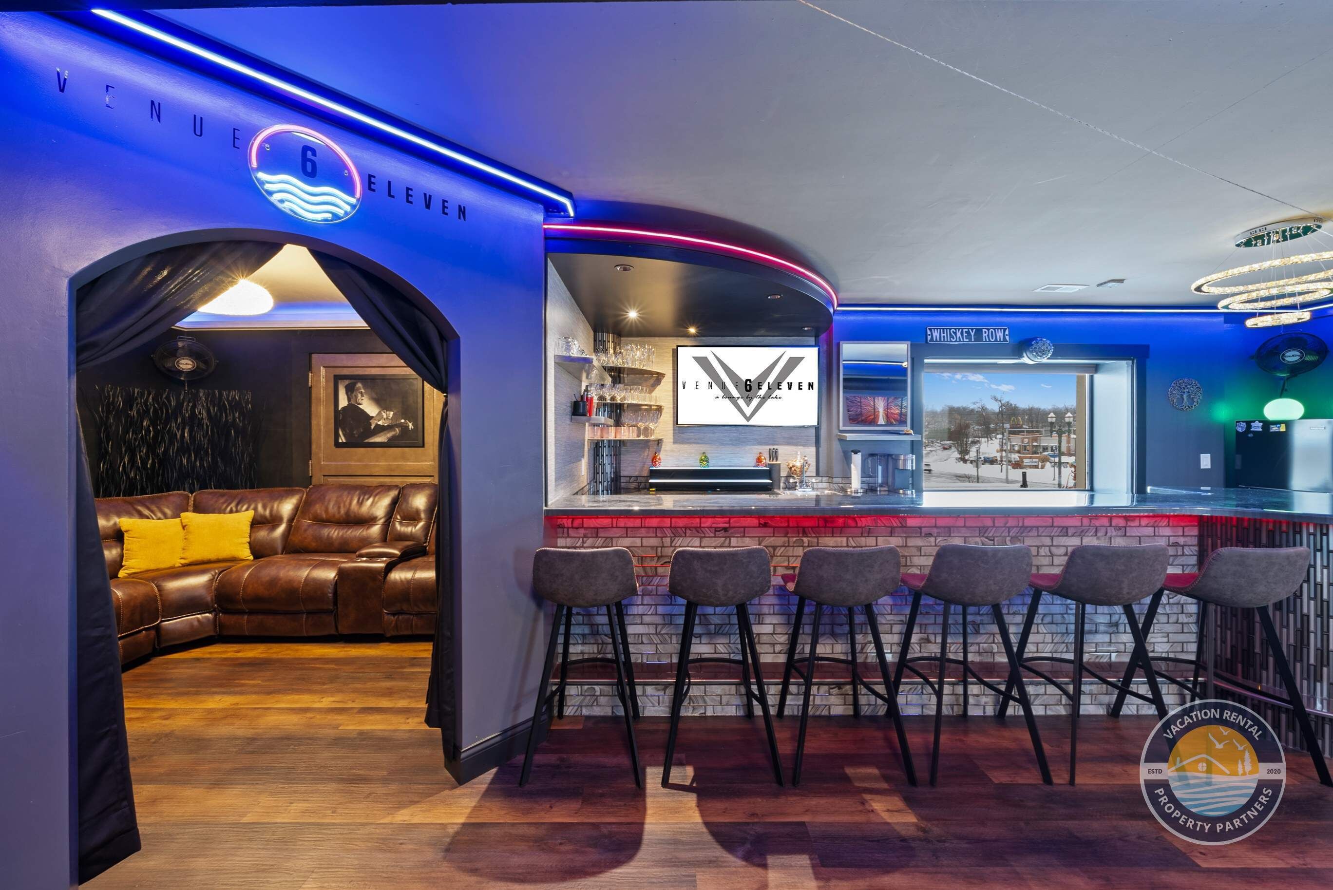 A bar area with a counter, bar stools, and a view of the city.