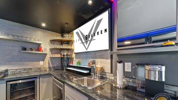 Une cuisine moderne équipée d’un four encastré, d’un évier et d’une machine à café.