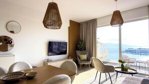 Uma sala de estar moderna com área de jantar, janelas amplas e uma vista, e cadeiras penduradas originais.