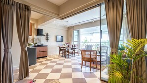 A spacious living area with a checkered floor, a dining set, and a balcony with curtains. - Staymaster Solintra 2BHK C401 (Verem)