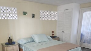 A bedroom with a bed, nightstand, and wardrobe. - Beautiful 3-Bedroom Home with Pool in Signal Hill (Signal Hill)