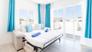 A bedroom with a bed, a sofa, and a view of the outside. - 1-Bedroom Apartment 'G' with Sofa Bed, Shared Pool, Wi-Fi & Air Conditioning (Felanitx)