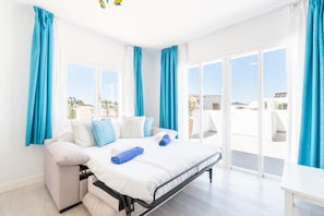 A bedroom with a bed, a sofa, and a view of the outside. - 1-Bedroom Apartment 'G' with Sofa Bed, Shared Pool, Wi-Fi & Air Conditioning (Felanitx)