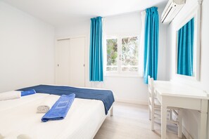 A bedroom with a bed, a desk, and a window with curtains. - 2-Bedroom Apartment 'D' with Shared Pool, Wi-Fi & Air Conditioning (Felanitx)