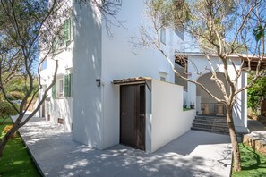 A white building with a dark door, green shutters, and a tiled roof. - 2-Bedroom Apartment 'F' with Shared Pool, Wi-Fi, and Air Conditioning (Felanitx)