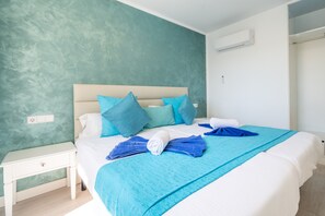 Ein Bett mit einem weißen Kopfteil, blauen Kissen und einer blauen Decke.