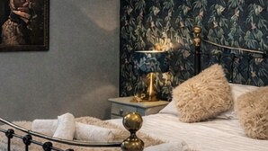 Une chambre à coucher avec un lit, une table de chevet, une lampe et un tableau au mur.