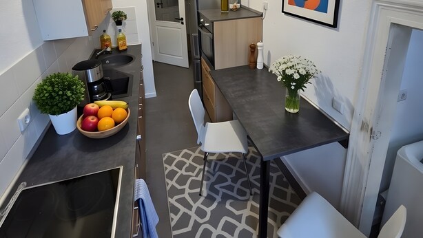 A modern kitchen with a dining area, a refrigerator, a sink, and a stove.
