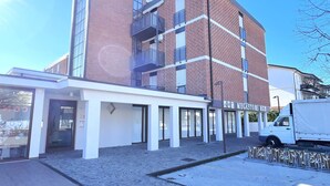 A modern building with a brick facade, large windows, and a sign for 'MEGASTORE'. - Charming Family Flat Near the Beach (San Michele al Tagliamento)