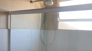 Chuveiro, toalhas de banho, papel higiênico