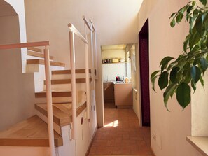 A staircase leading to a kitchen with a tiled floor and a plant on the right. - Kiki's - A spacious house with a garden in the Langhe. (Castagnole delle Lanze)