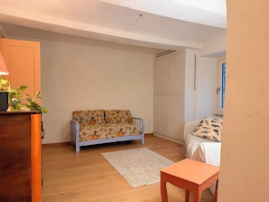 A room with a sofa, a small table, a wardrobe, and a bed. - Kiki's - A spacious house with a garden in the Langhe. (Castagnole delle Lanze)