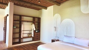 A bedroom with a wooden wardrobe, a bed, and a unique wall design.