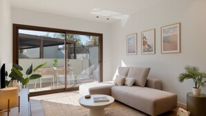 En moderne stue med sofa, sofabord og billedkunst på væggen.