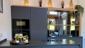 Une cuisine moderne dotée d’appareils électroménagers intégrés, d’une grande fenêtre et d’objets décoratifs.