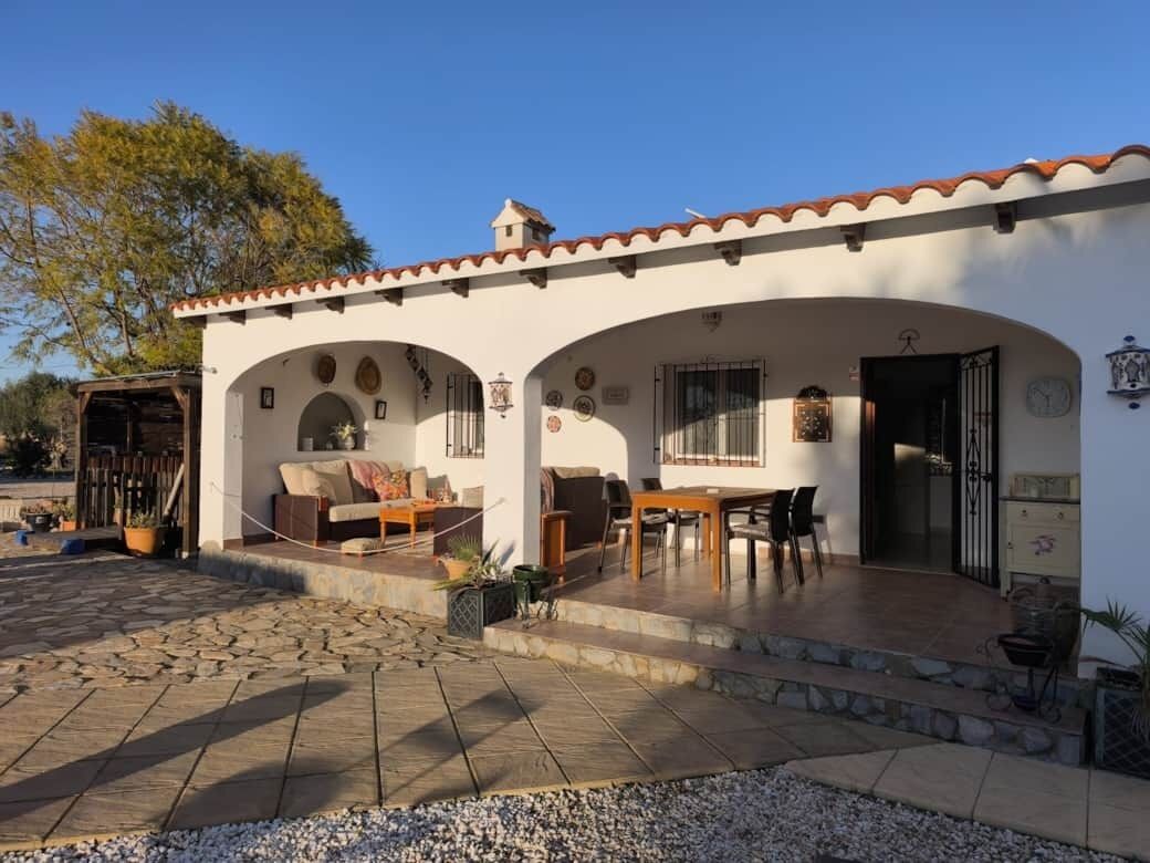 A building with a patio area, a dining table, and a sofa.