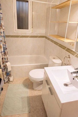 A bathroom with a bathtub, toilet, sink, and a shower curtain. - Quiet villa with pool, Mojácar (Villa Mojacasa) (Mojácar)
