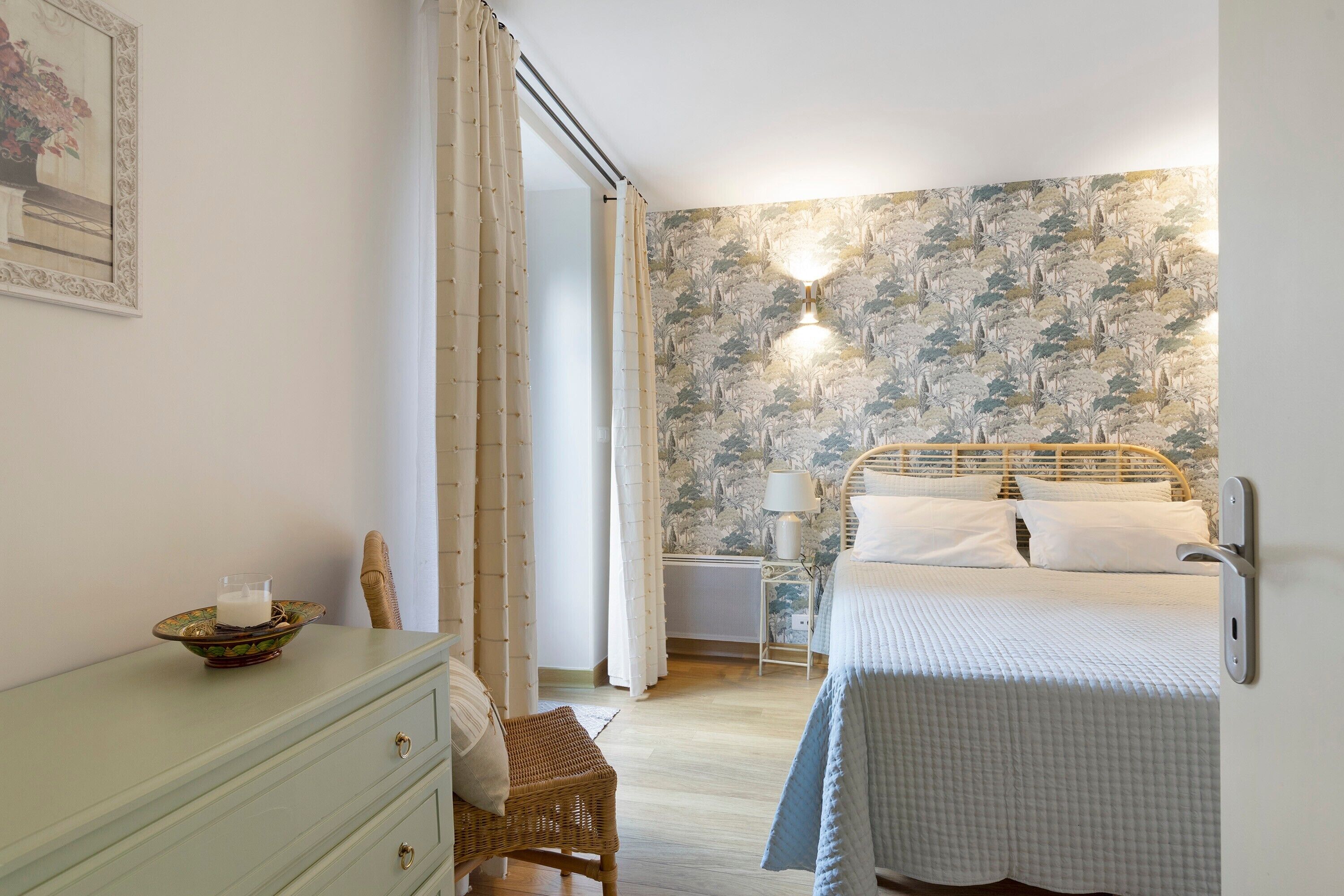 Un dormitorio con cama, mesita de noche, lámpara, cómoda y silla.