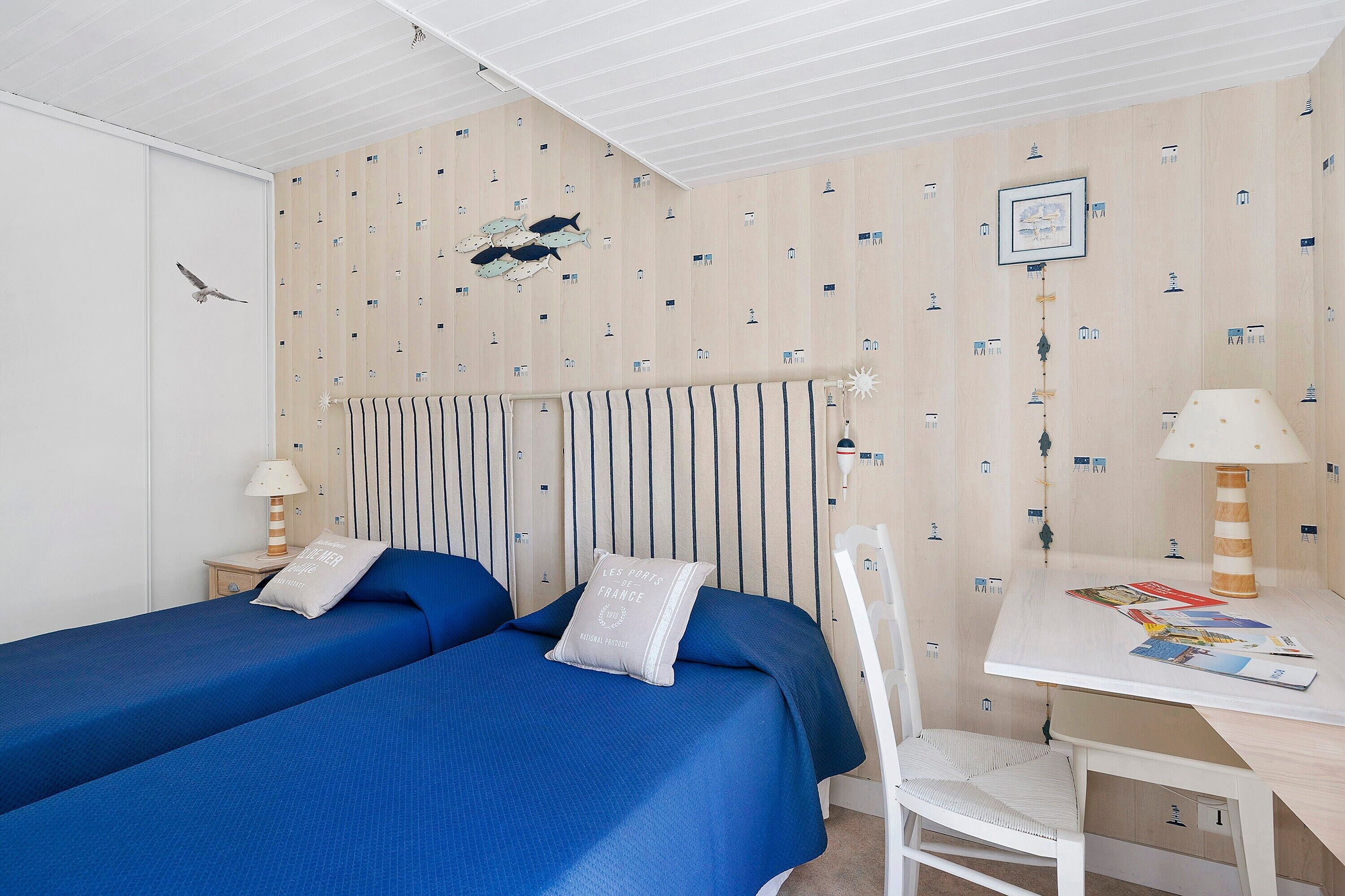 A room with two beds, a desk, and a chair.