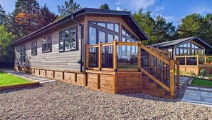 A cabin with a wooden exterior, large windows, a wooden staircase, and a gravel driveway. - Host & Stay | Marble Lodge (Beverley)