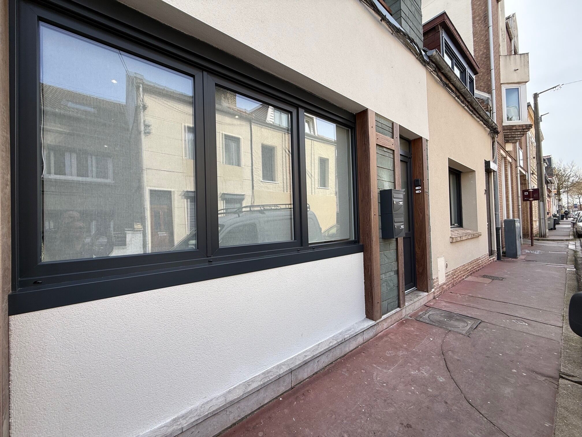 A building facade with large windows, a door, and a mailbox.