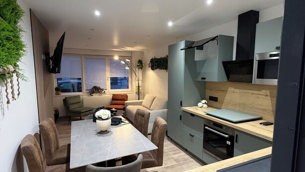 A modern kitchen with a dining area, built-in appliances, and a view of the outdoors. - Elegant T2 Design & Comfort - Premium Getaway (Calais)