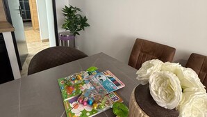 A dining table with a book, a decorative cake, and a potted plant. - Elegant T2 Design & Comfort - Premium Getaway (Calais)