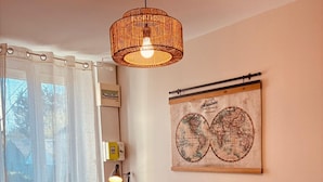 Ein Wohnzimmer mit einem braunen Ledersessel, einem runden Couchtisch, einer Topfpflanze, einer Weltkugel als Kunstwerk und einer Hängelampe.