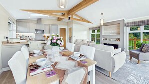 A modern kitchen with a dining area, a sofa, and a fireplace.