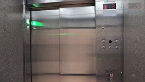 An elevator with a digital display, emergency buttons, and a control panel. - Cjour loft Apartment (Montréal)