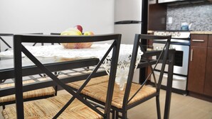 A kitchen with a dining table, chairs, a fruit bowl, and modern appliances. - Cjour loft Apartment (Montréal)