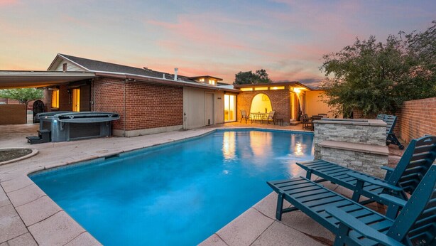 A backyard with a swimming pool, a hot tub, and a barbecue area. - Sip & Swim | Heated Pool • Hot Tub • Games (Tucson)