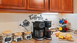 A kitchen with a coffee maker, jars labeled 'Coffee Pods' and 'Sugar,' and a 'Coffee Bar' sign.