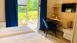 Une chambre d’hôtel avec deux lits, un bureau, une chaise, une télévision et une vue sur l’extérieur.